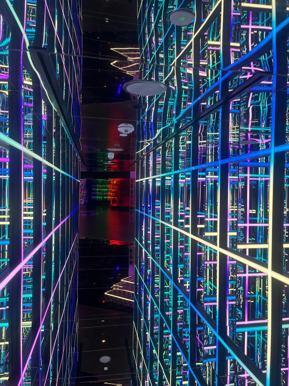 Neon-lit hallway with multi-colour LED strips creating an infinite perspective grid